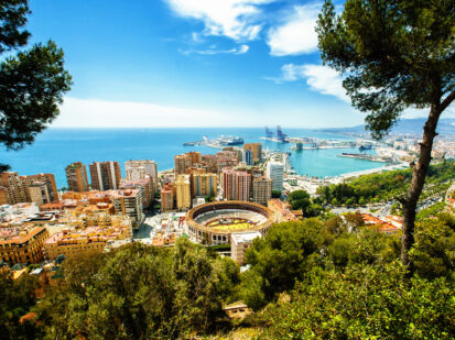 Eine wunderschöne Aussicht auf Malaga in Spanien. Ein wunderschönes Stadtbild mit vielen bunten Gebäuden, einer Stierkampfarena, den Hafen, viel Grünfläche und das wunderschöne türkisfarbene Meer.
