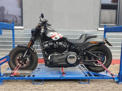 Zu sehen ist eine Harley-Davidson, die auf einem von uns speziell angefertigtem Motorradgestell verzurrt ist. In diesen Gestellen werden alle Motorräder auf unserem LKW verladen.